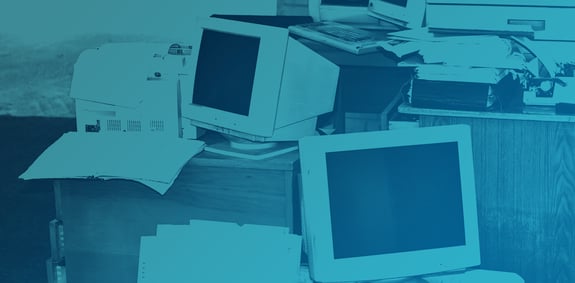Desk piled with papers, binders and computers